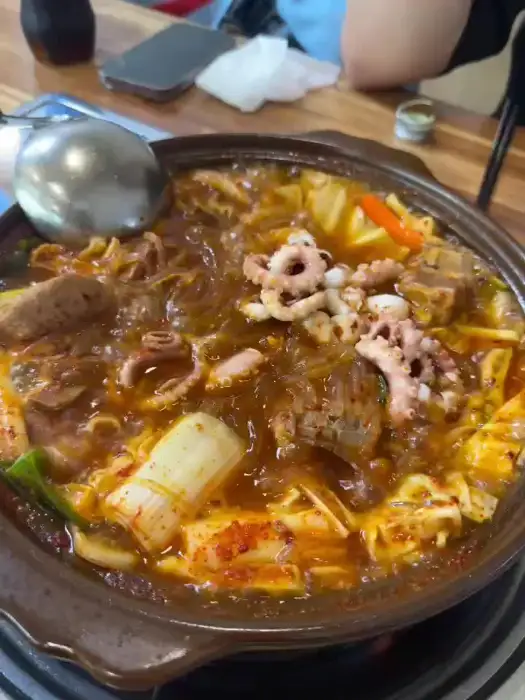 갈비찜 국물과 함께 낙지, 당면을 집는 모습 - 진한 양념 국물이 잘 배어든 낙지와 당면이 먹음직스럽습니다.