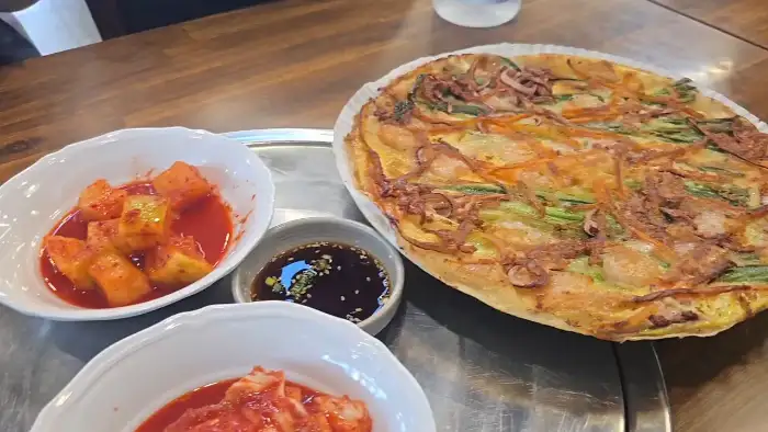 김치, 깍두기, 소스가 함께 나온 파전 사진