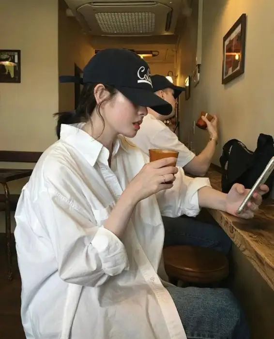 흰 셔츠를 입고 컵을 들고 있는 여성