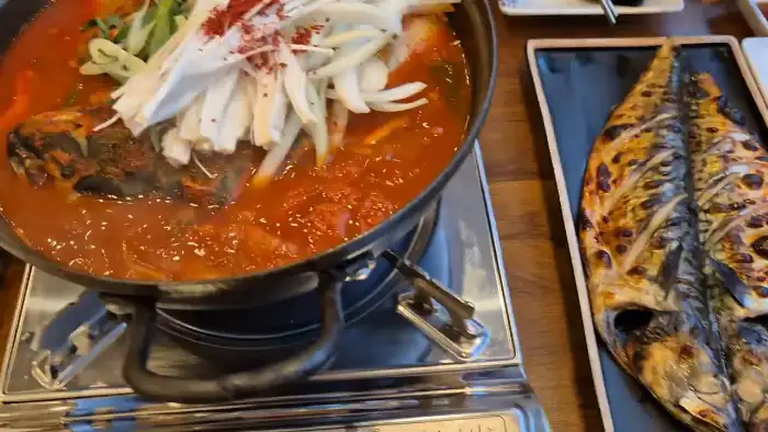 뚝배기에 담긴 빨간 국물의 갈치조림과 옆에 놓인 고등어구이