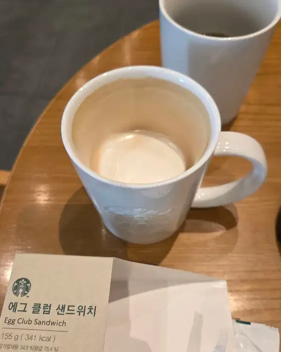 샌드위치 포장지와 텅 빈 머그잔