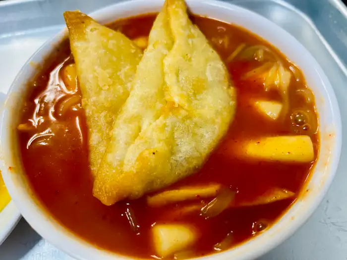 떡볶이 국물 위에 얹어진 군만두 두 개