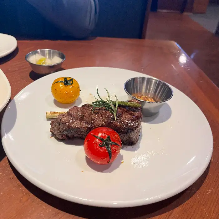 스테이크와 토마토, 허브로 장식된 접시