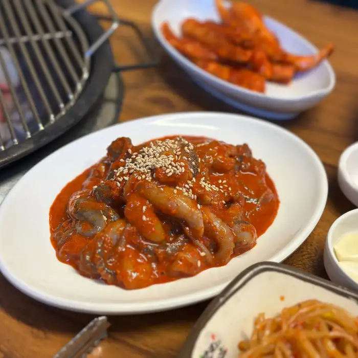 고추장 양념이 밴 삼겹살이 숯불 위에서 구워지고 있는 모습
