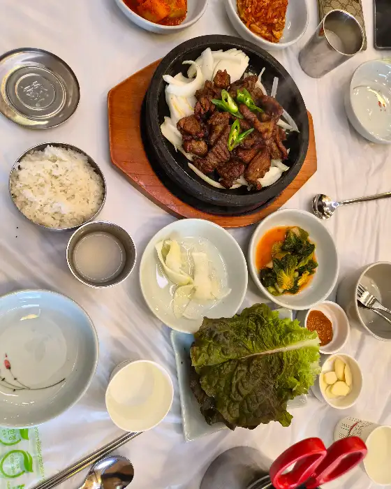 석갈비와 밥, 쌈 채소, 밑반찬이 함께 놓인 모습