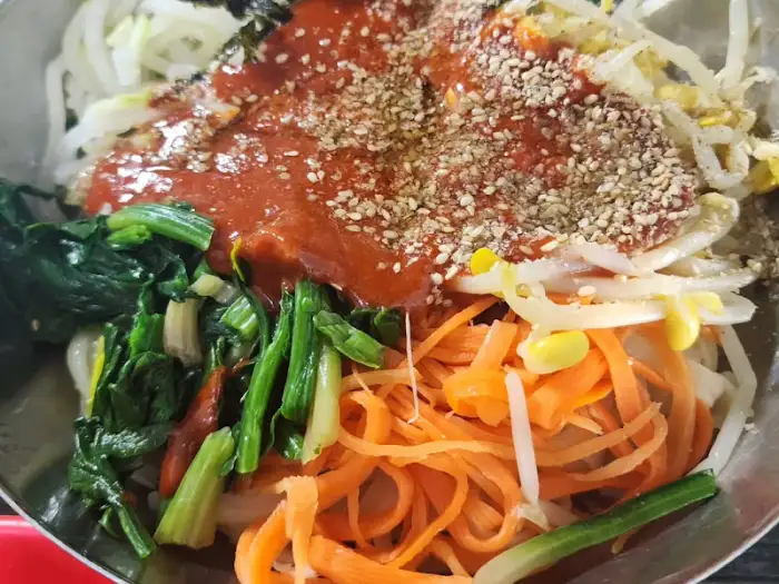 다채로운 나물과 함께 비벼진 비빔칼국수