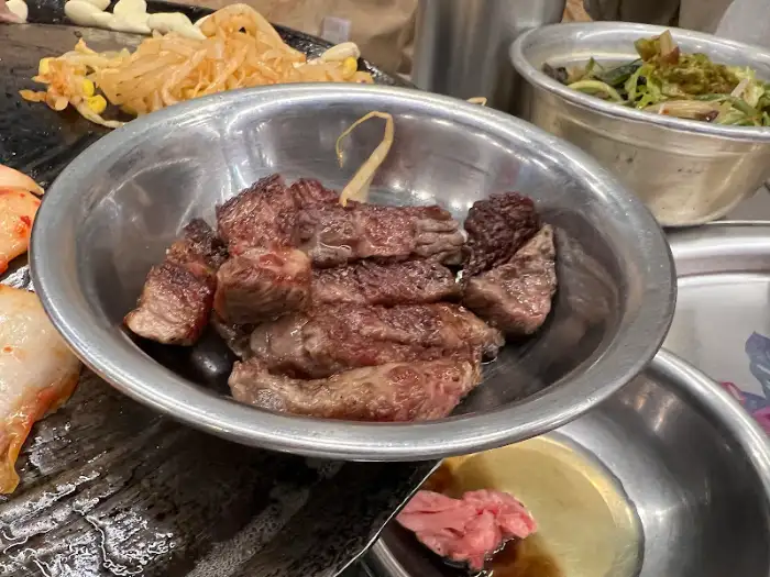 스테인리스 그릇에 담긴 먹음직스러운 구운 고기 조각들