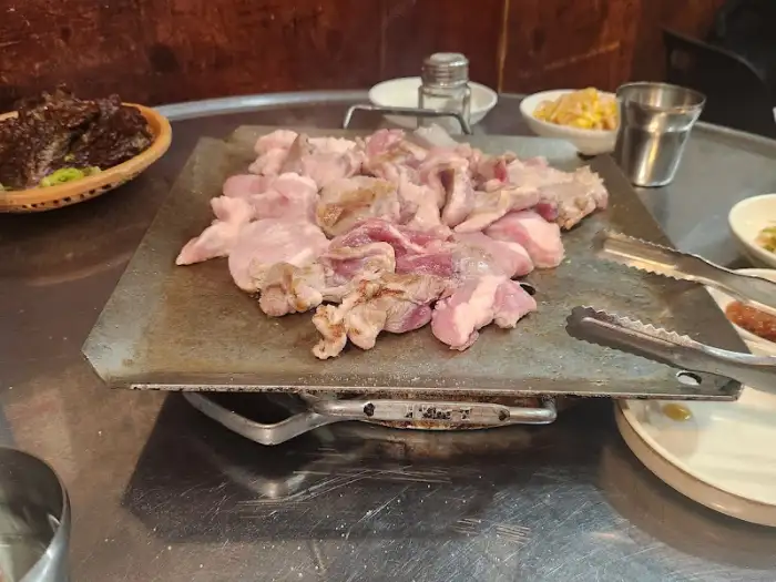 달궈진 불판 위에 올려진 신선한 뒷고기 덩어리들