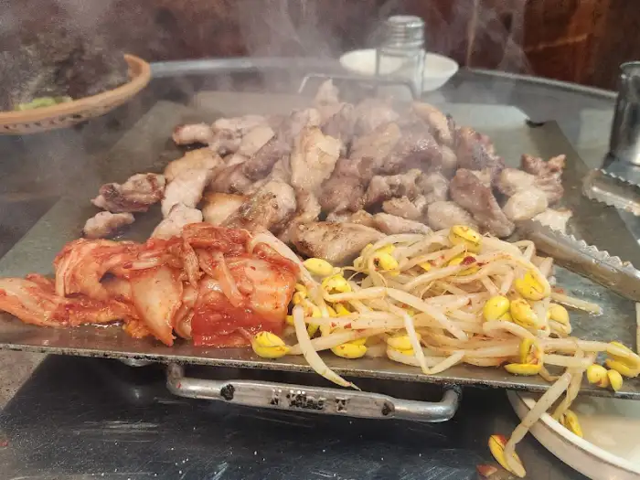 불판에 김치와 콩나물을 함께 구워 먹는 모습