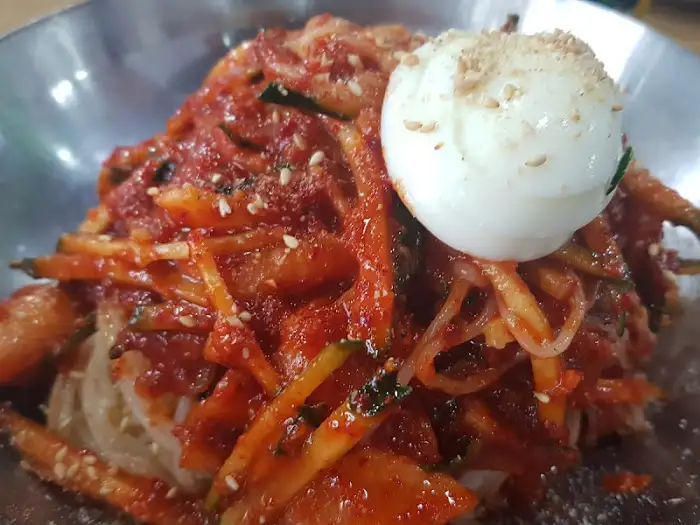 비빔밀면 위에 놓인 삶은 계란