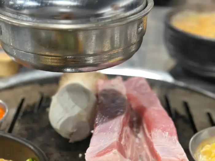 두툼한 삼겹살 덩어리, 옆에 버섯과 마늘