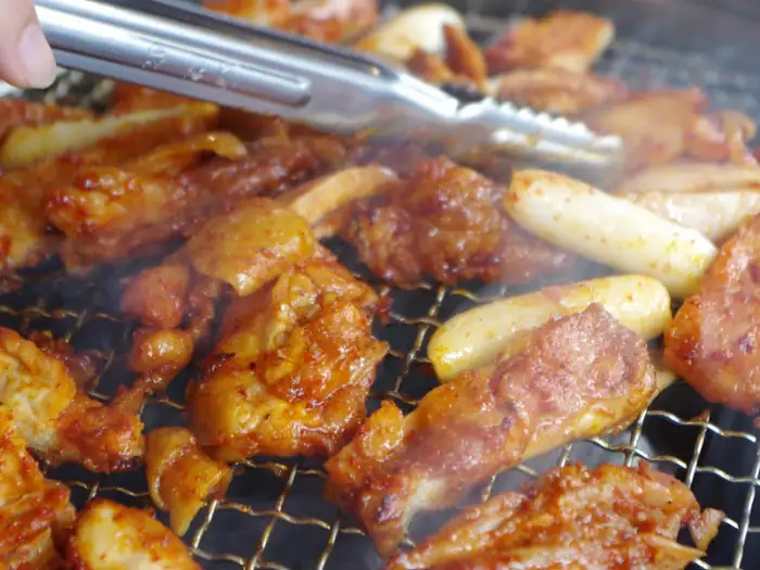 숯불 위에서 익어가는 닭갈비 조각들