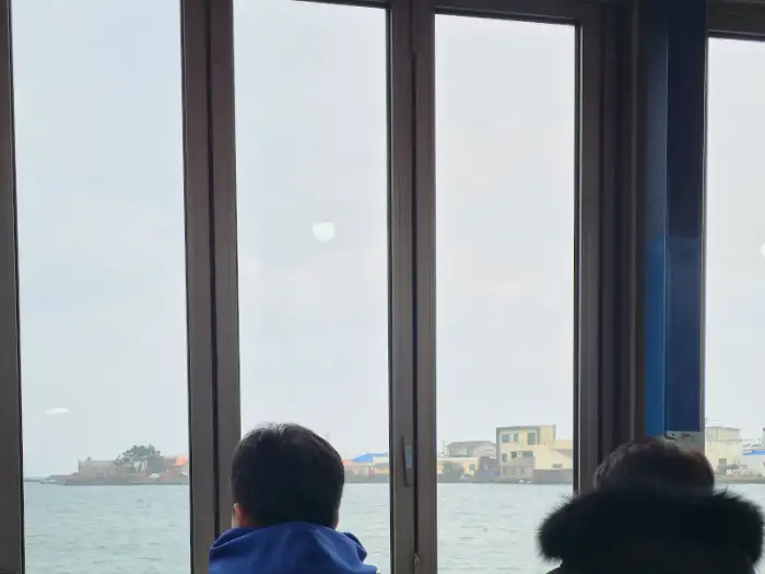 창밖으로 보이는 바다 풍경과 이를 바라보는 사람들