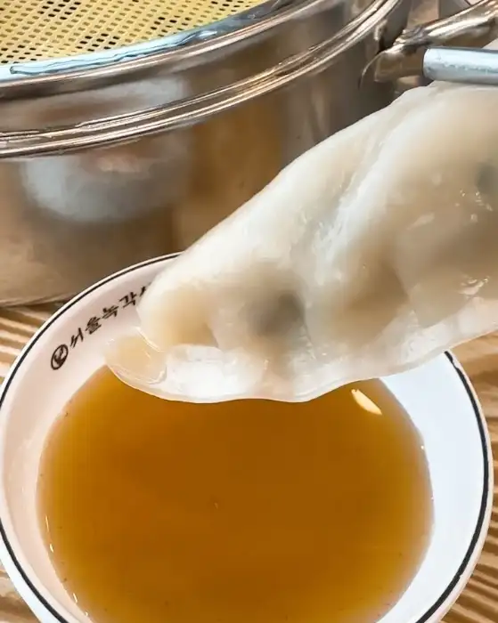 만두를 간장 소스에 찍어먹는 모습