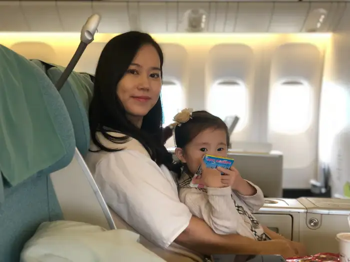 귀여운 아이와 함께 비행기에 앉아있는 여성