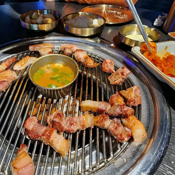 잘 익은 고기를 집게로 집어 올리는 모습
