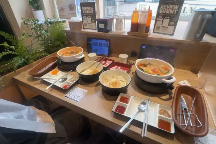 샤브샤브 조리 중 - 끓는 육수에 채소와 고기를 넣고 있는 모습