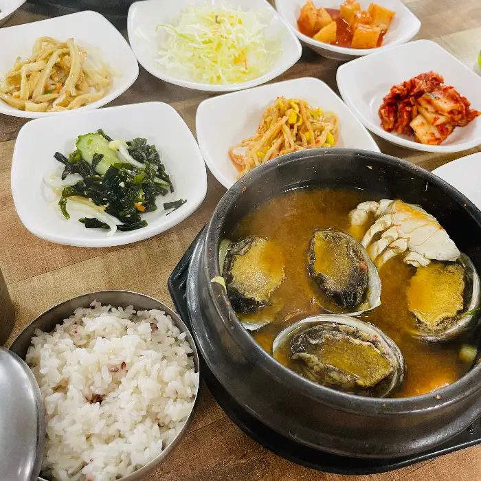 전복이 여러 개 들어있는 해물 전복 뚝배기와 밥
