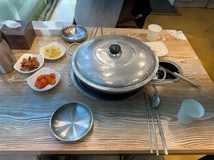 식탁 위에 놓인 부대찌개 냄비와 반찬들. 혼밥 세팅이 깔끔하다.