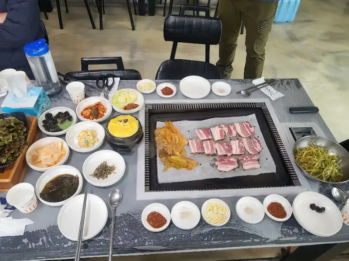 불판 위에서 노릇하게 익어가고 있는 약돌돼지 삼겹살
