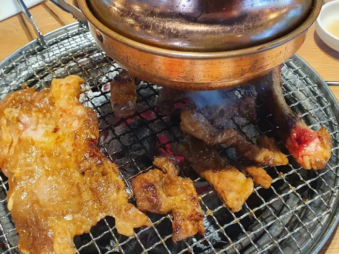 숯불 위에서 구워지고 있는 돼지갈비와 삼겹살