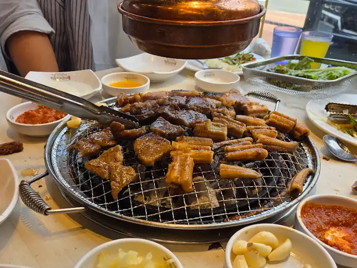직원이 집게로 고기를 뒤집는 모습