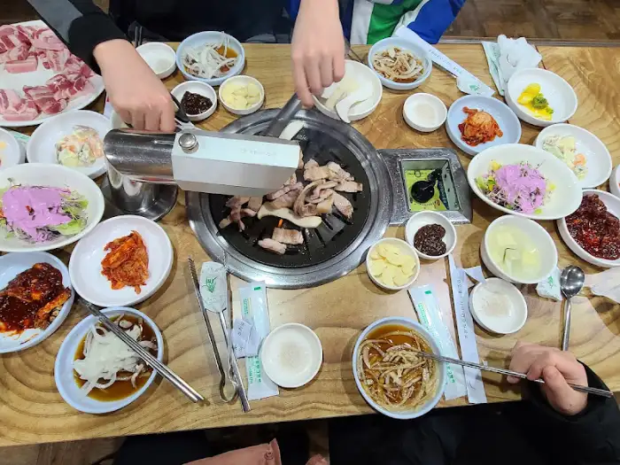 불판 위에서 익어가는 고기와 다양한 반찬들