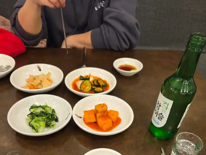 식탁에 놓인 다양한 밑반찬과 술병