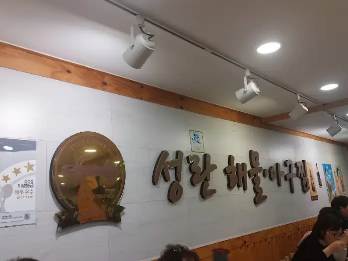 가게 내부 모습, 벽면에 걸린 금색 장식과 상호명이 보인다.