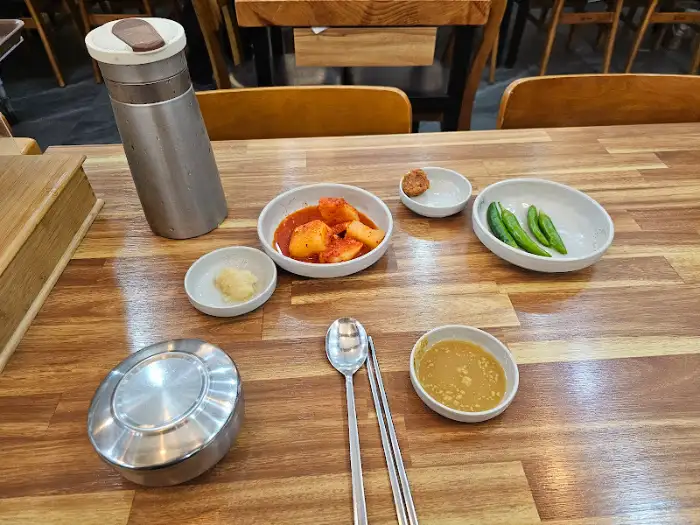 테이블에 놓인 물통과 식기류