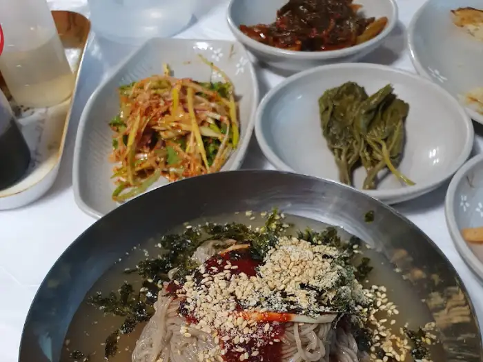 막국수와 여러 가지 반찬이 차려진 테이블 모습