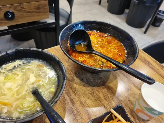 뜨거운 국물이 담긴 뚝배기와 맑은 국물의 뚝배기, 그리고 한 컵의 물