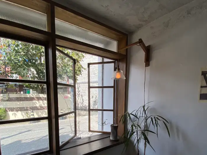활짝 열린 창문 너머로 보이는 바깥 풍경과 내부의 따뜻한 조명