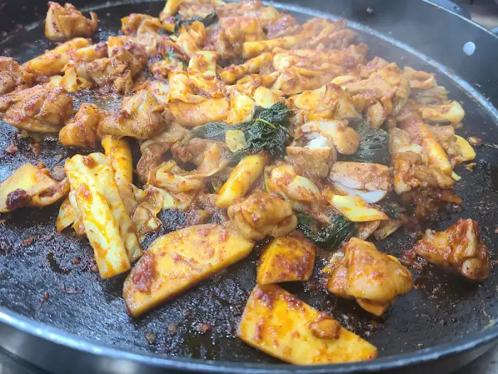잘 익은 닭갈비 조각과 떡, 채소가 어우러진 모습