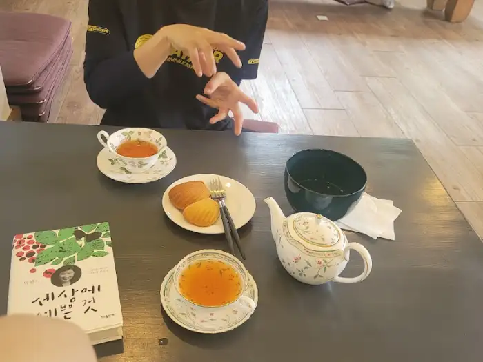 두 잔의 홍차와 마들렌, 그리고 책 한 권이 놓인 테이블