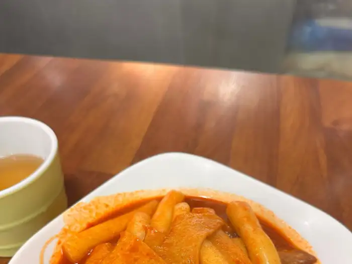 떡볶이가 담긴 접시와 컵에 담긴 차