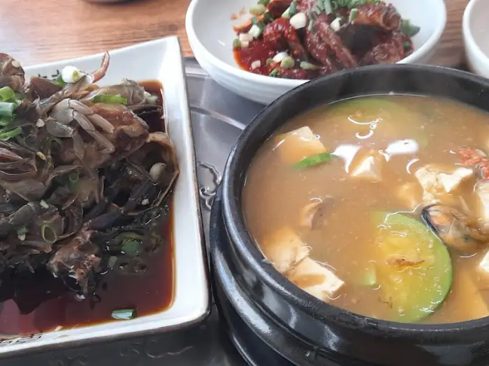 돌게장, 된장찌개, 볶음 요리가 담긴 여러 그릇