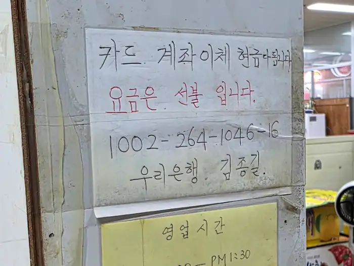 가게 벽에 붙은 결제 정보 및 영업 시간 안내