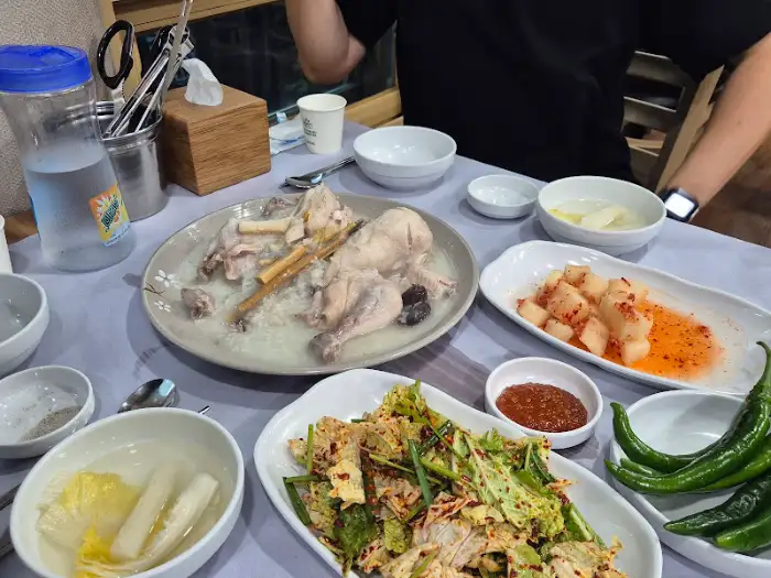 테이블 위에 놓인 여러 가지 반찬과 닭백숙