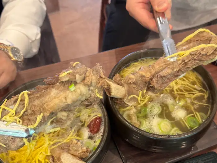 집게로 갈비탕 고기를 자르는 모습