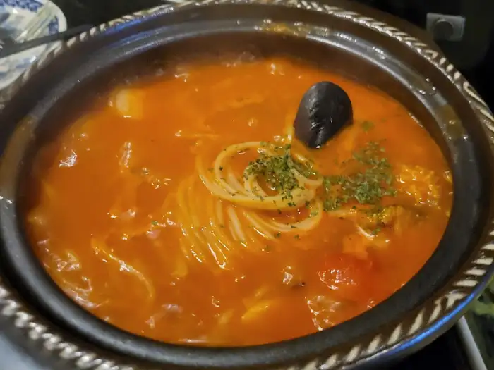 뚝배기에 담긴 붉은 국물의 파스타 클로즈업