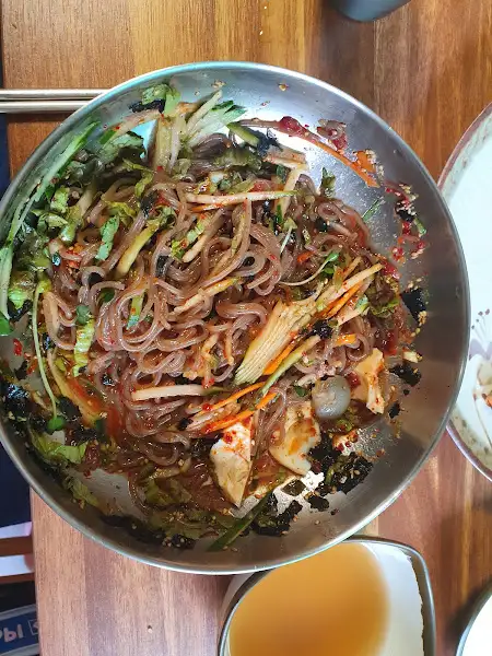 그릇에 담긴 낙지 비빔밥. 다양한 채소와 낙지가 섞여 있다.