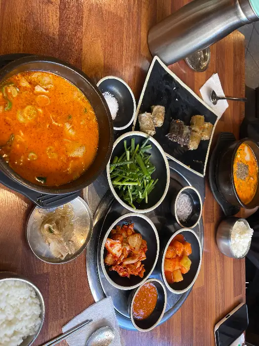 식탁에 놓인 얼큰한 국물 요리와 다양한 반찬들