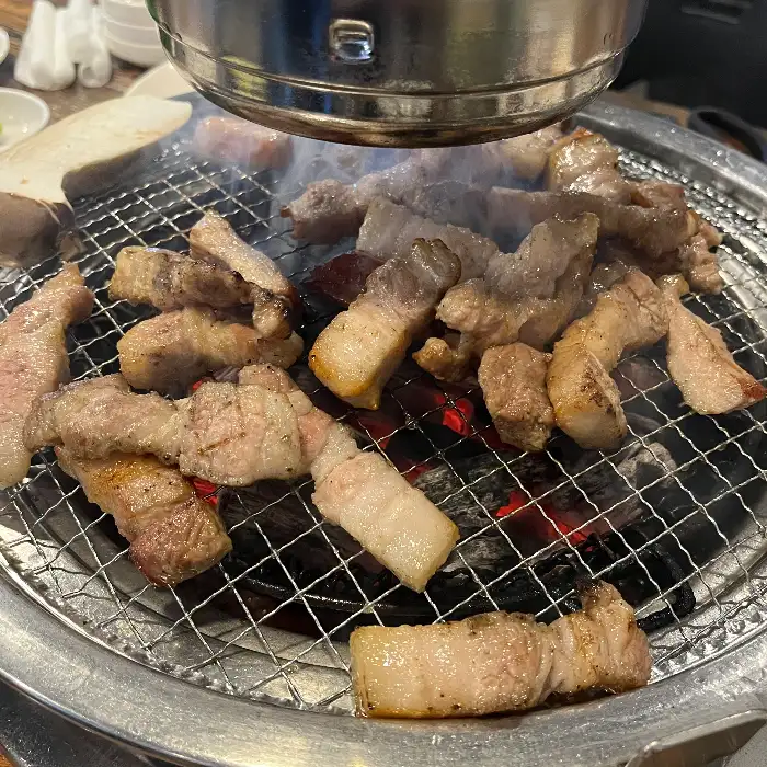 숯불 위에서 구워지고 있는 삼겹살과 목살