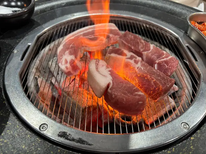 숯불 위에서 맛있게 구워지는 돼지고기