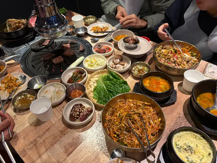 테이블 가득한 한우 구이와 반찬들