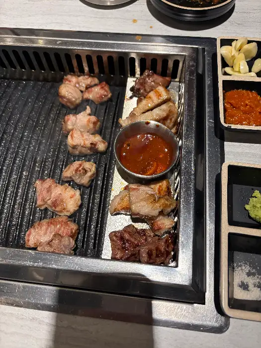 불판 위에서 맛있게 익어가는 삼겹살과 목살.