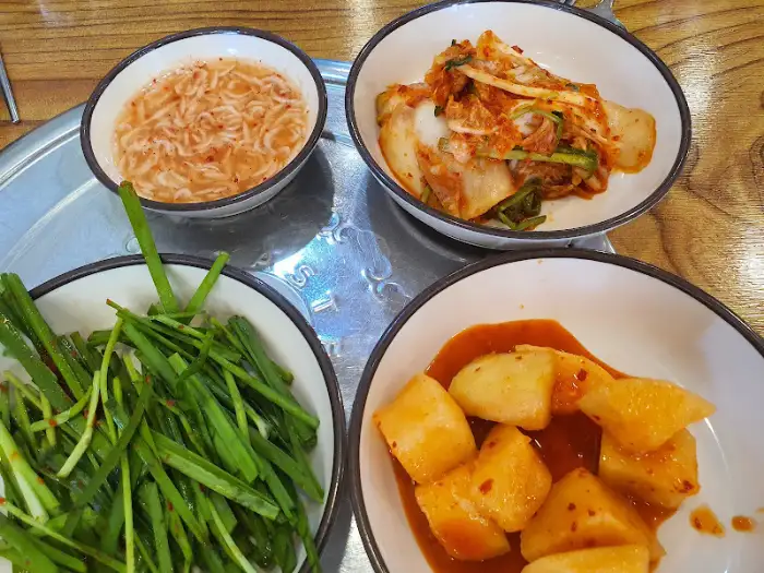 다양한 반찬과 메인 메뉴가 테이블 위에 차려진 모습