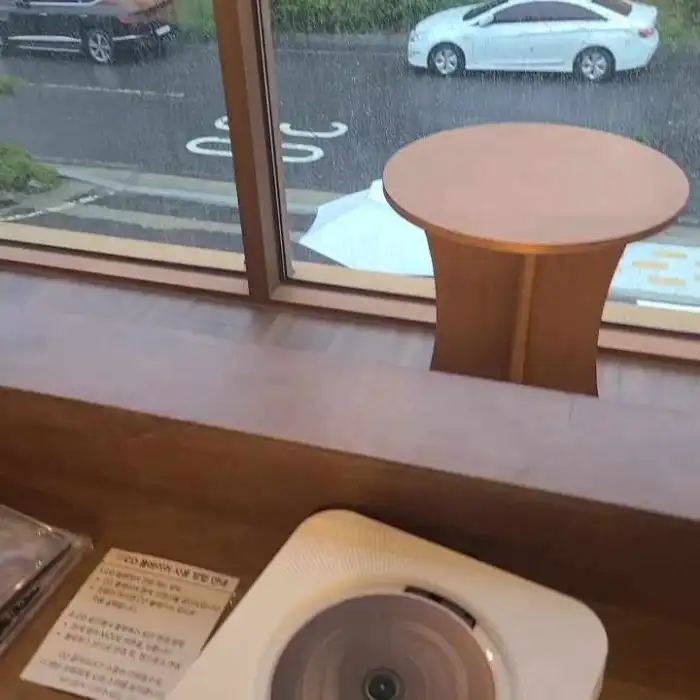 카페 내부 테이블과 창밖 풍경이 보인다.