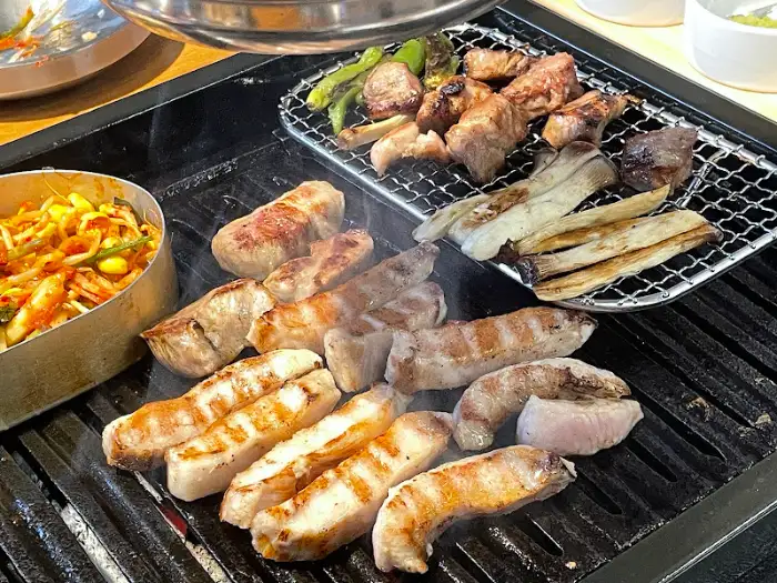 구워지고 있는 고기와 곁들임 음식